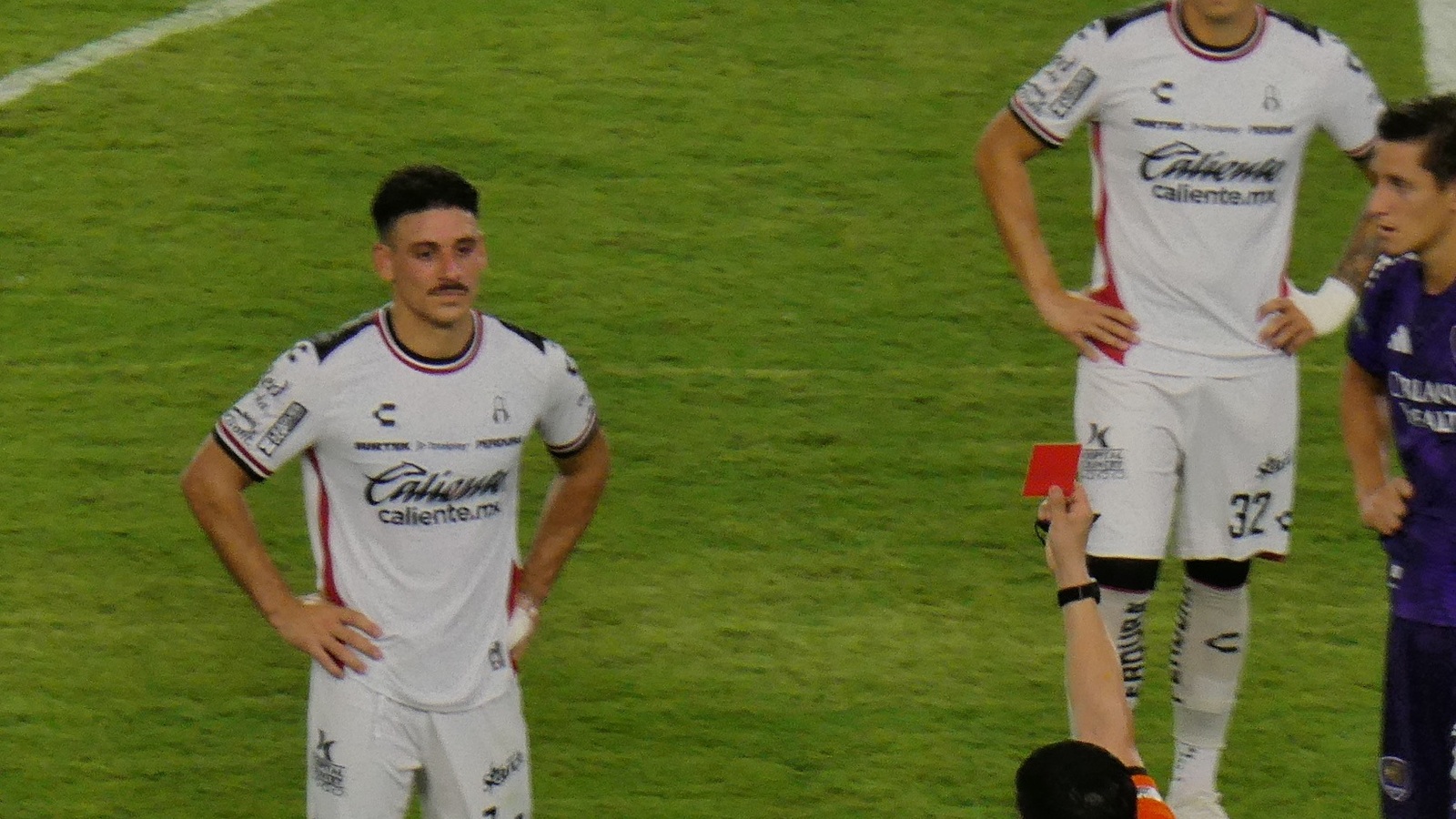 Un árbitro muestra la tarjeta roja a un jugador
